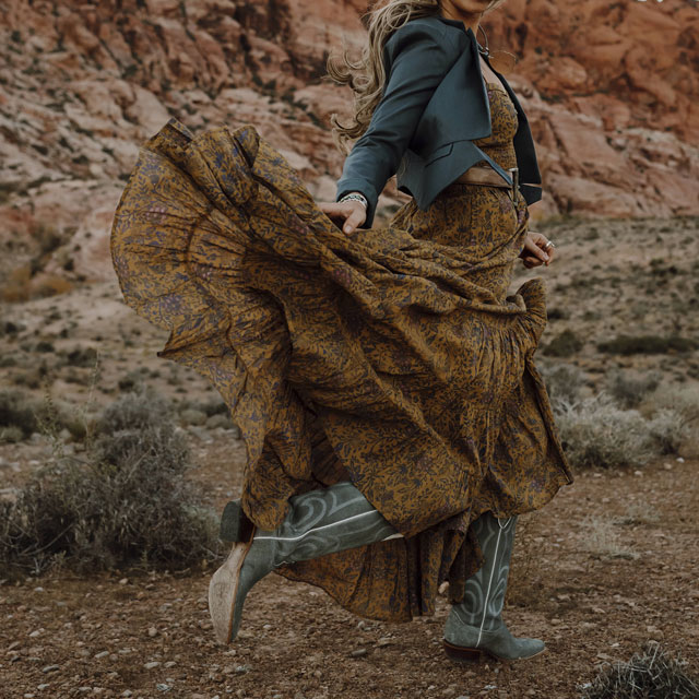 A woman wearing Justin Vintage boots dancing in the desert 